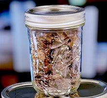 Load image into Gallery viewer, Black Sesame Seed Toffee Brittle Bits inside of glass Bell jar with sliver lid.