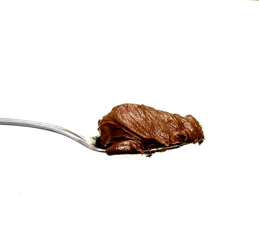 A spoonful of thick, glossy chocolate spread or nut butter on a plain white background.