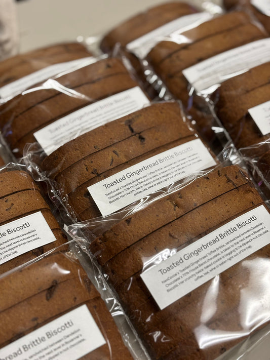 Packaged toasted gingerbread brittle biscotti with labels on a neutral background