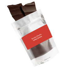 Load image into Gallery viewer, Smoky Mocha packaging with toffee brittle spilling out. Red label with NeoCocoa logo and title of product and net weight of product.