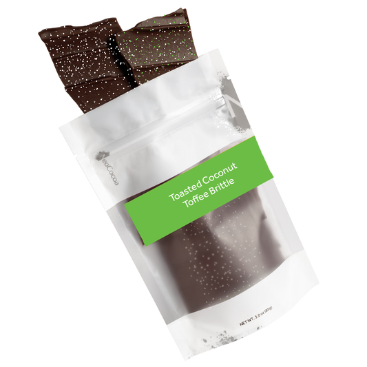 Toasted Coconut  brittle pouring out of 3oz sized bag with green label stating “Toasted Coconut Toffee Brittle” and NeoCocoa logo on a white background.