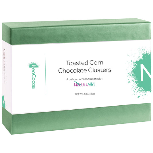A rectangular box of NoCocoa Toasted Corn Chocolate Clusters, featuring a white label with green accents and text, set against a plain white background.