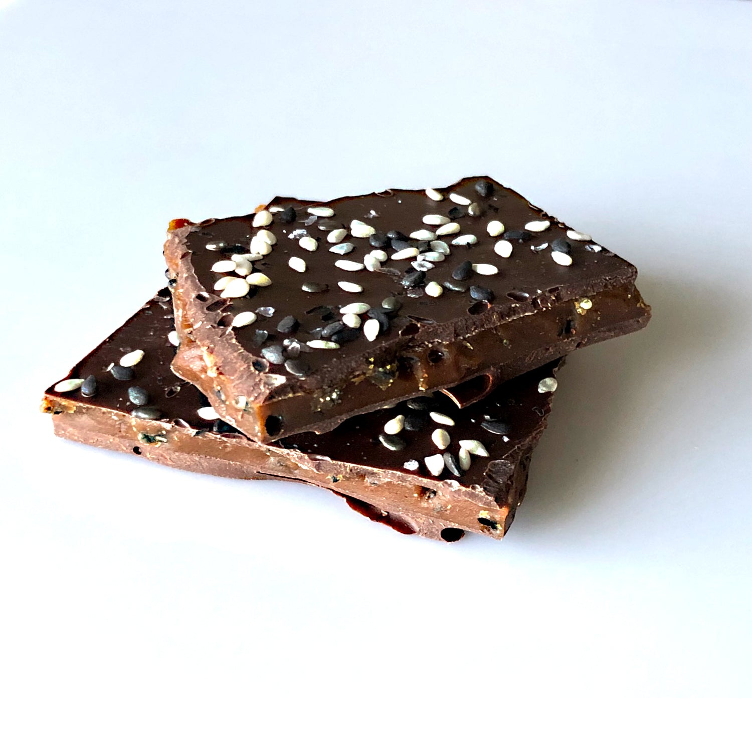 Close up of 2 stacked pieces of the sesame brittle candy.
