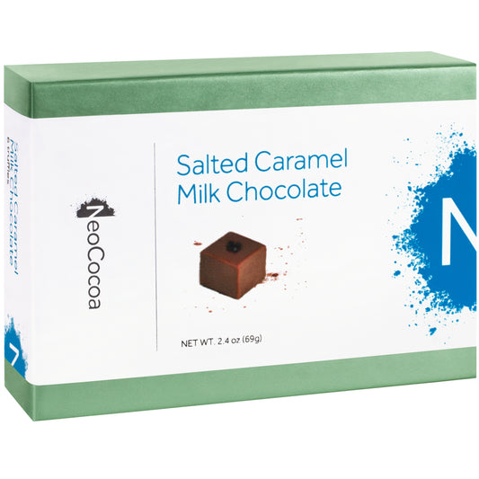 Closed 2 dimensional green rectangle box with a label wrapped around the center of the box stating, “Salted Caramel Milk Chocolate” with NeoCocoa logo and net weight 2.4 oz (69g). With a single image of the truffle with a little bit of cocoa powder sprinkles. 