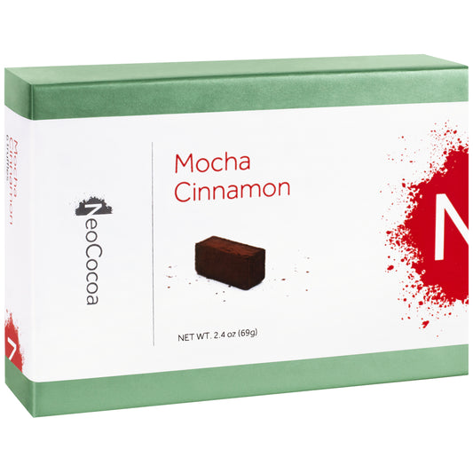 Closed 2 dimensional green rectangle box with a label wrapped around the center of the box stating, “Mocha Cinnamon” with NeoCocoa logo and net weight 2.4 oz (69g). With a single image of the truffle with a little bit of cocoa powder sprinkles