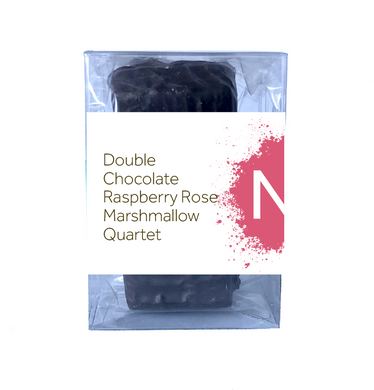 Front side of dark chocolate covered chocolate marshmallows in the clear bag inside of a clear plastic box, wrapped with a label stating “Double Chocolate Raspberry Rose Marshmallow Quartet” with yellow NeoCocoa logo.