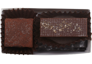 Inside the rectangle box, 1 cube shaped lime truffle (coated in cocoa powder) and 1 rectangle shaped almond butter truffle with a few flakes of salt. 