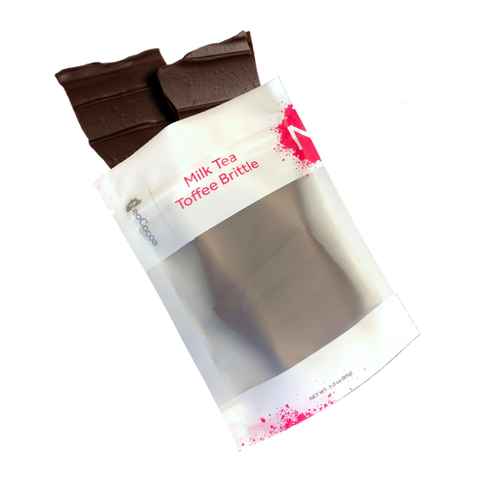 Milk Tea brittle pouring out of 3oz sized bag with label stating “Milk Tea Toffee Brittle” and a pink NeoCocoa logo.