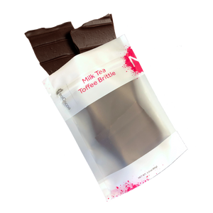 Milk Tea brittle pouring out of 3oz sized bag with label stating “Milk Tea Toffee Brittle” and NeoCocoa logo.